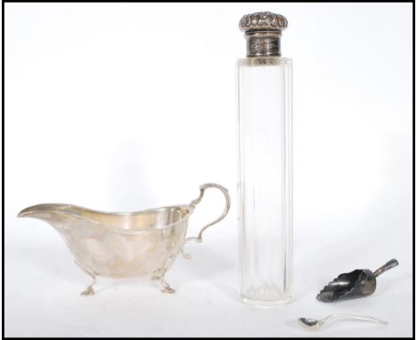 A silver hallmarked sauce boat being raised on cab feet with a shaped scrolled handle with an acanthus leaf to the top (hallm