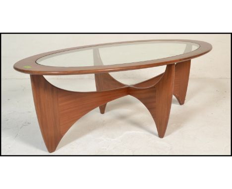 A mid century Victor Wilkins for G-Plan Oval Astro glass top teak coffee table. Lozenge form with cross over teak wood legs a