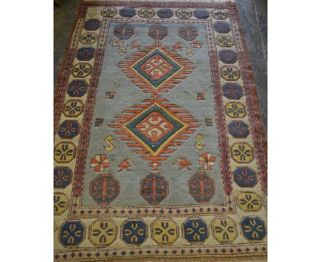 A 20th Century oriental woven blue ground geometric floor rug having a central blue panel with a large red medallion, the cre