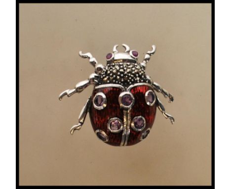 A silver and enamel bug brooch. The brooch in the form of a ladybird with red body and inset amethyst stones. Pin Verso. Tota