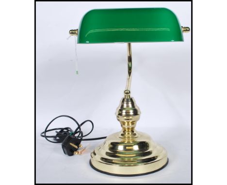 A vintage style bankers desk lamp having an adjustable green glass shade raised on a brass support and stepped brass base.&nb