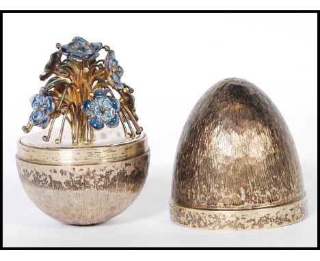 A silver hallmarked Stuart Devlin limited edition surprise egg having a textured exterior opening to reveal a cascade of enam