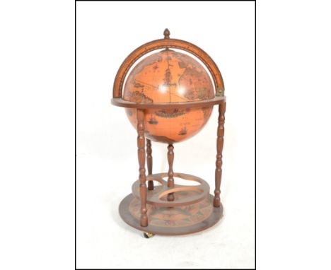 An antique style floor standing cocktail drinks cabinet in the form of a terrestrial globe with hinged top section to fitted 