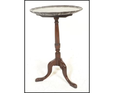 A 19th century mahogany wine table of good proportions. The tripod base with scrolled legs and turned column supporting a sca