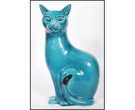 A Poole studio pottery ceramic figurine modelled as a seated cat with a turquoise glaze. Stamped to the base. Measures 30 cm 