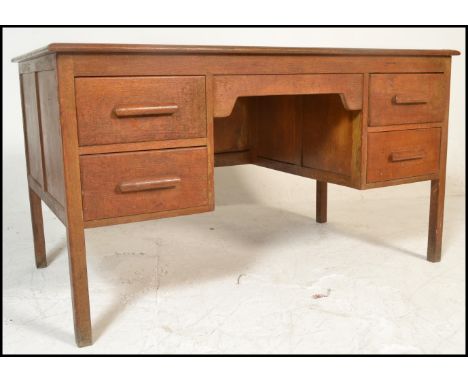 A vintage 20th Century Air Ministry style twin pedestal oak desk, the flared top supported by a twin bank od two drawers rais