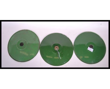A set of three vintage 20th Century industrial enamel factory shades, the shades of UFO form, green enamel to the top with wh