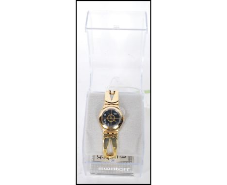 A ladies swatch ' For Your Eyes Only ' 007 James Bond wrist watch having a gold tone strap with a round black dial set with w