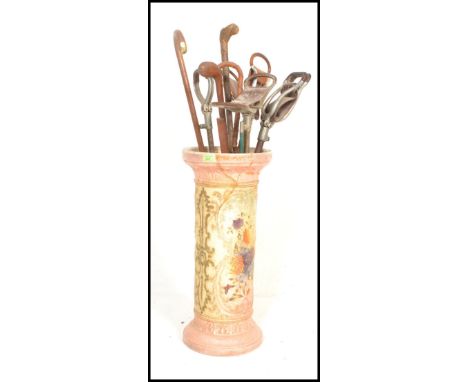 An early 20th Century stoneware stick stand together with a collection of four stick stands and various walking canes&nbsp;