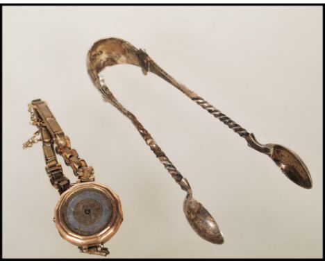 A vintage early 20th Century 9ct gold Art Deco cocktail watch along with a pair of Victorian hallmarked silver sugar tongs.