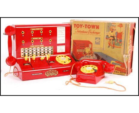 A vintage 1950's Codeg made Toy-Town Telephone exchange tinplate toy within it's original box. Measures; 20cm tall.&nbsp;
