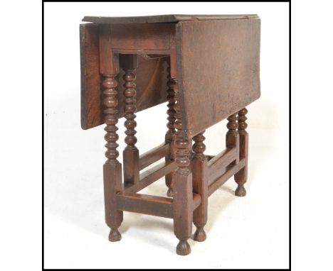 A 17th century country oak drop leaf table. Raised on bobbin turned supports with peg jointed construction having drop leaves