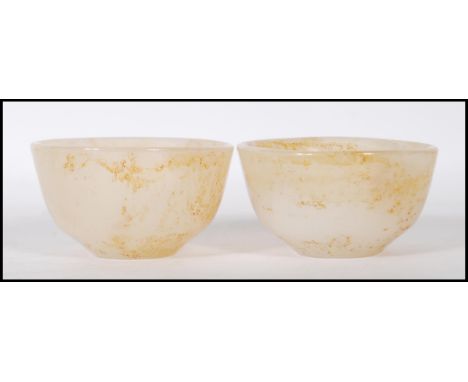 A pair of Chinese white jade bowls having applied brown mottled effect.&nbsp;Measures: 8cm diameter.