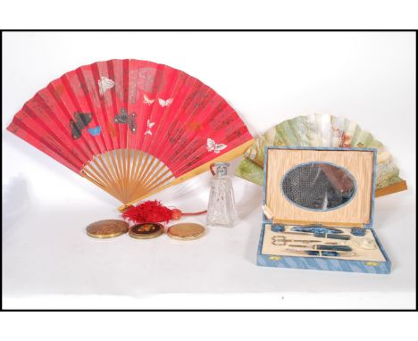 A group of three vintage compacts, all having floral decoration atop. Together with two fans one advertising Parfum Vivitz L.