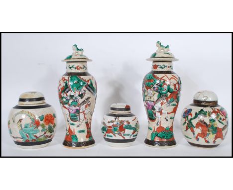 A pair of Chinese crackle glaze ceramic lidded vases decorated with warriors, the lids with foo dog finials together with lid