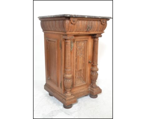 An early 20th Century oak pedestal hall cabinet / cupboard / pot stand. Topped with rouge marble over a single carved panel d