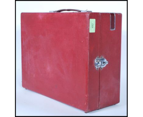 An early 20th Century vintage HMV wind-up picnic gramophone in a red carry case, metal fittings and corner mounts.