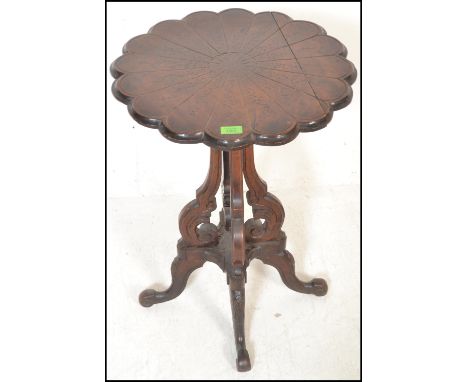 A late 19th Century high Victorian mahogany wine / occasional table, the scalloped top having sectional carved foliate panels