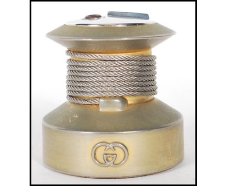 A vintage 20th Century Gucci table lighter of round form having a silvered logo to the front, and wire rope to the centre.&nb