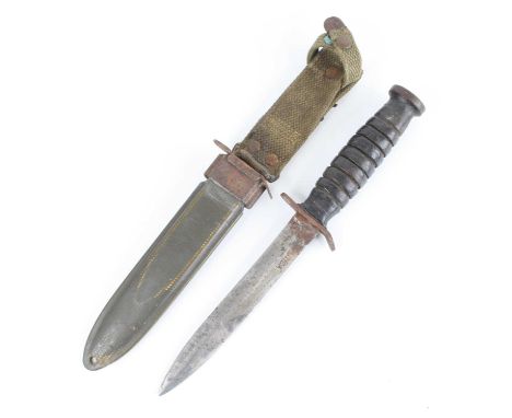 A US Army M3 trench knife, the 16.5cm blade marked US M3 UTICA, having an eight groove leather grip with steel pommel, housed