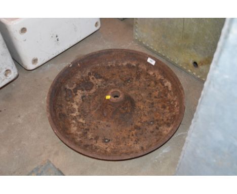 A small cast iron circular pig trough, drilled out as a planter