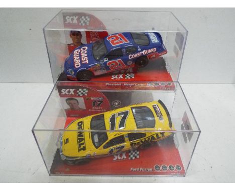 SCX - 2 x Slot Cars in 1:32 scale. # 62730 Chevrolet Monte Carlo and # 62690 Ford Fusion. Vehicles appear mint in perspex pre