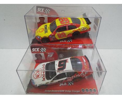 SCX - 2 x Slot Cars in 1:32 scale. # 62680 Dodge Charger and # 63380 Chevrolet Impala SS Harvick. Vehicles appear mint in per