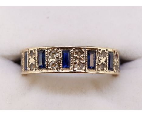 A yellow metal eternity ring set baguette cut sapphires interspersed with pairs of chip diamonds, size R to S 