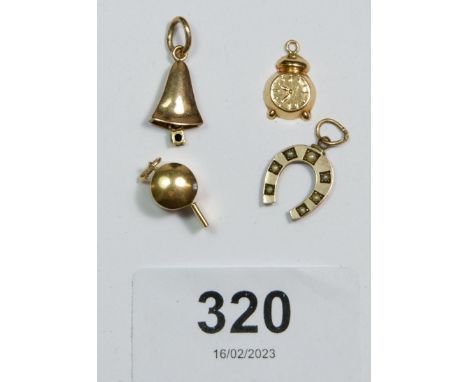 Four small gold charms in the form of a whistle, bell, horseshoe and a clock, 3.5g, unmarked but tested as gold 