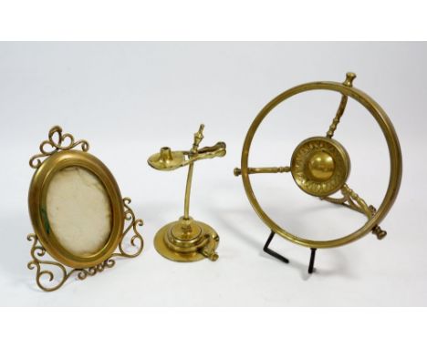 An oval brass photograph frame by Asprey &amp; Son, 17cm, an easel trivet and a rush holder or taper stick