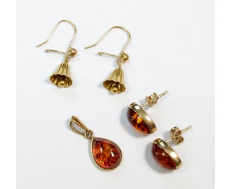 A 9 carat gold and amber pendant with matching earrings and a yellow metal bell pair of earrings 