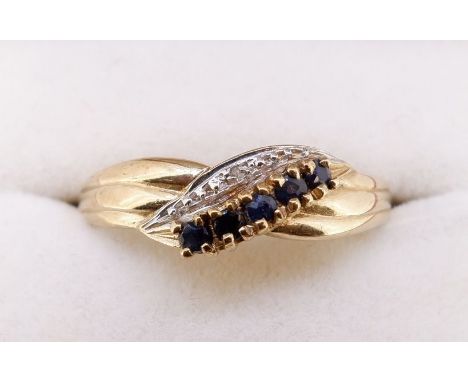 A 9 carat gold ring crossover set line of sapphires, size T, 2g 