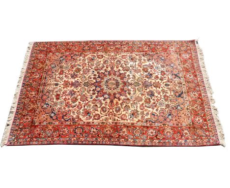 A Tafresh carpet, the madder field decorated with floral motifs in tones of red on a cream ground, conforming borders, 228cm 