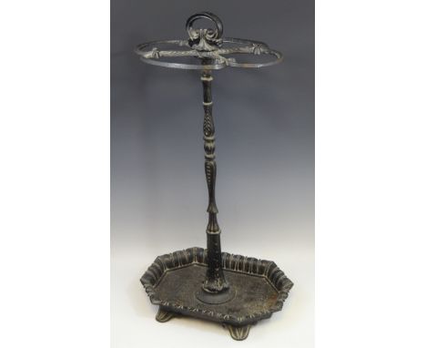 A Victorian cast iron walking stick stand, posted loop handle above four C-scroll divisions, dished canted rectangular base w