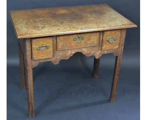 A George III oak lowboy, rectangular top, the frieze fitted with one long and two deep cockbeaded drawers, shaped apron cante