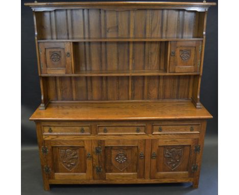 A contemporary farmhouse oak dresser, oversailing cornice, two  fielded paneled doors, carved Tudor Rose , the projecting bas