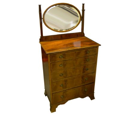 An Edwardian Sheraton Revival mahogany dressing chest, oval mirror, moulded oversailing top, five graduated drawers, spreadin