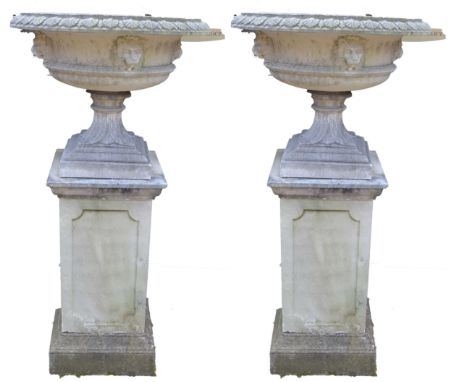 A pair of Regency design composition saucer-shaped garden urns, each with acanthus moulded everted rim, above lion masks, squ
