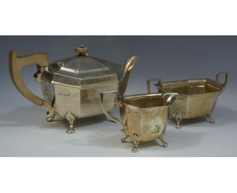 An Art Deco silver three piece canted rectangular tea service, comprising teapot, milk jug and sugar basin, angular scroll ha