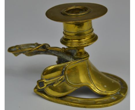 A 19th century brass novelty novelty chamber stick, cast as a saddle, fetlock and riding crop handle, cylindrical sconce with