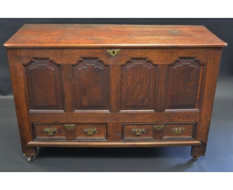 An 18th century oak mule chest, hinged top above four shaped raised and fielded panels, the base with two drawers, brass bat 