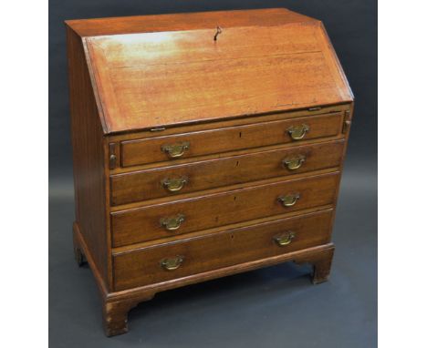A George III oak bureau, fall front enclosing an arrangement of pigeon holes and small drawers, above four long drawers, bras