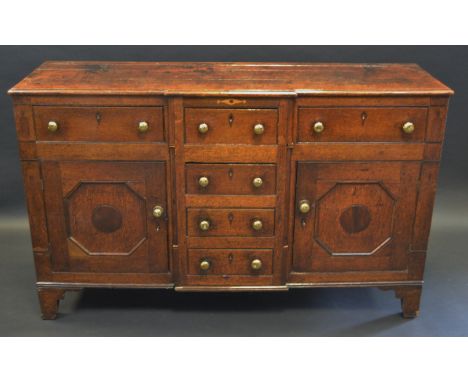 A George III oak breakcentre low dresser, slightly oversailing top with moulded edge above a T-shaped arrangement of six draw