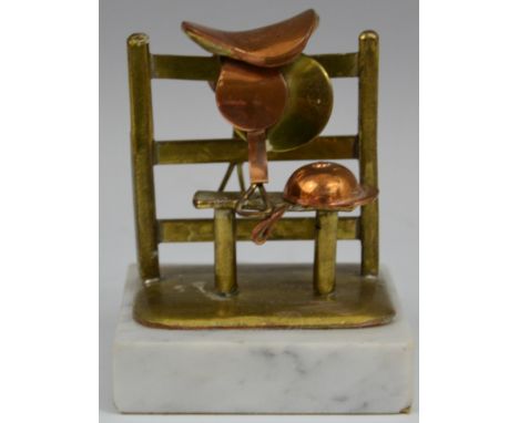 Equestrian - Horse Racing - a copper and brass novelty desk weight, as a jockey's cap and saddle, set down at a stile, marble