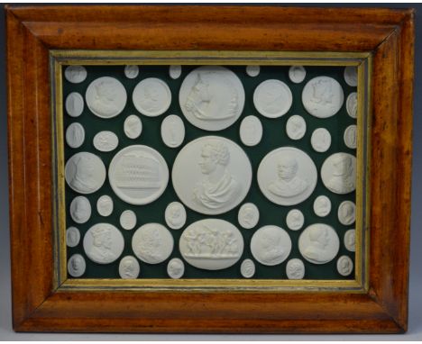 An arrangement of plaster intaglios, mostly profile portrait medallions, 24cm x 32cm, maple frame