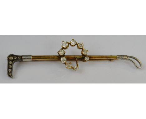 Hunting Interest - an early 20th century gold coloured metal riding crop stick pin, mounted with horse shoe set with nine gra
