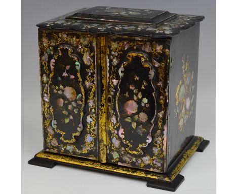 A Victorian papier mâché table cabinet, shaped shallow sarcophagus cresting above a pair of doors enclosing three drawers, in