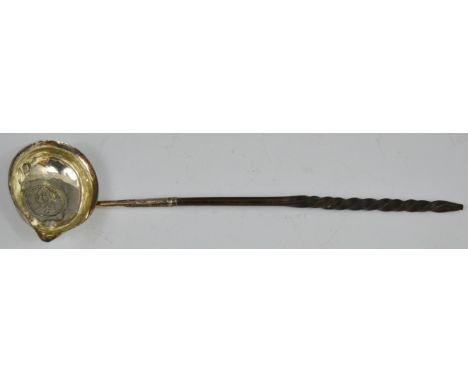 A George III toddy ladle, the bowl inset with coin, wrythen whale bone handle, 29cm long, London 1792