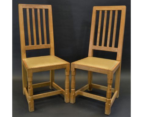 Robert Thompson, Mouseman of Kilburn - a pair of oak dining chairs, rectangular slatted backs, brass studded seats, panelled 