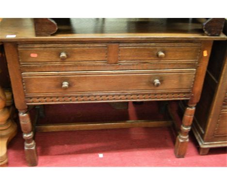 A contemporary joined oak side table, having two long drawers, raised on ring turned supports, united by lower stretchers, wi